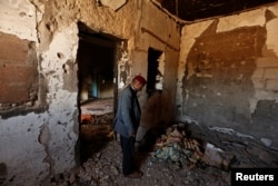 FILE - Hamid Ishi stands in his house, which was taken over by Islamic State jihadists and damaged during fighting with government forces, in Ben Guerdane, Tunisia, April 10, 2016.