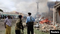 Soldiers look from a distance at the scene of a suicide attack in Mogadishu July 12, 2013.