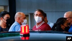 FILE - Brazilian President Jair Bolsonaro, center, leaves Vila Nova Star hospital after being discharged in Sao Paulo, Brazil, Jan. 5, 2022. Bolsonaro had been admitted for tests after experiencing abdominal discomfort.