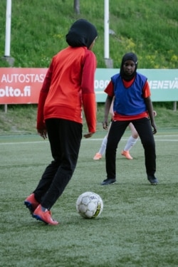 Kamila Nuh (kiri) dan Nasro Bahnaan Hulbade, keduanya mengenakan jilbab olahraga, berlatih sepak bola di Stadion MUP di Vantaa, Finlandia, 1 Juni 2021. (AFP)