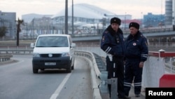 Russian traffic police stand guard on a road near venues at the Olympic Park near Sochi, January 7, 2014. 