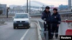 FILE - Russian traffic police stand guard on a road near venues at the Olympic Park near Sochi, Jan. 7, 2014. 