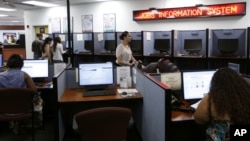 People use computers to look for work at WorkForce One in Hollywood, Florida, August 1, 2012.