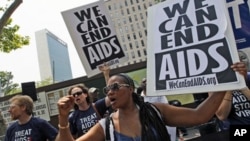 Cassandra James, right, Emily Bass, and Mitchell Warren chant slogans during a demonstration in New York. AIDS activists from around the world rally outside the United Nations headquarters calling for full funding for global AIDS treatment and prevention,