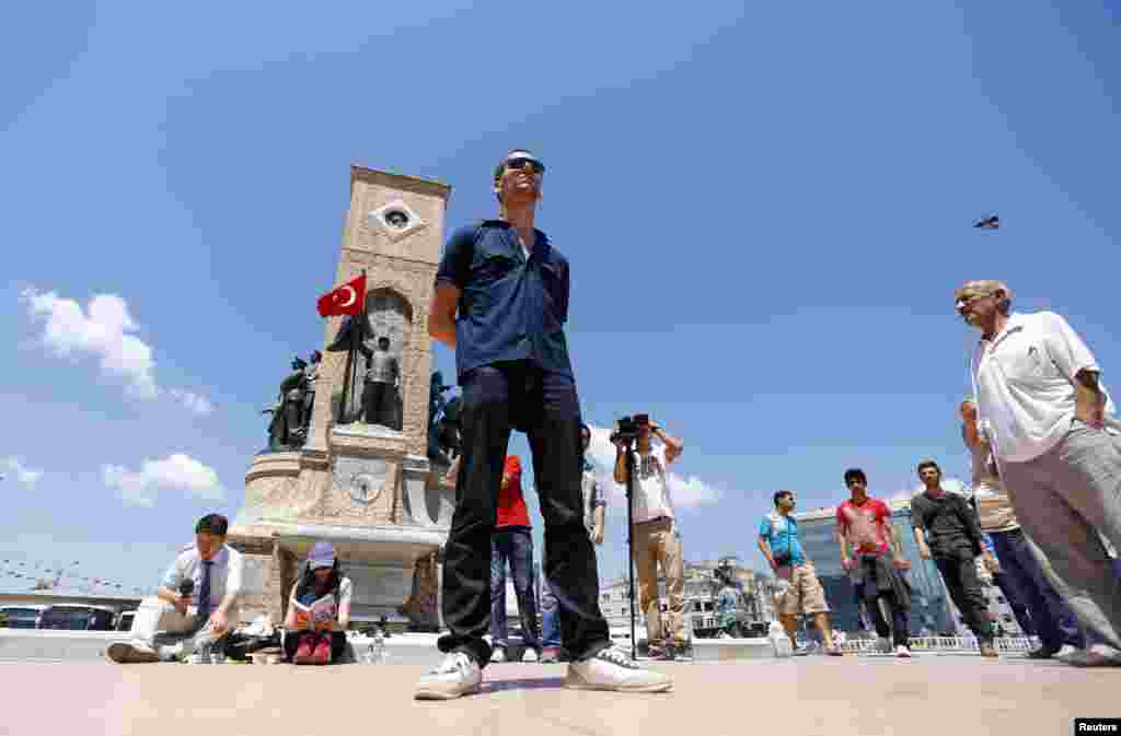 A man stands during a silent protest in Taksim Square in Istanbul, Turkey, June 18, 2013. 