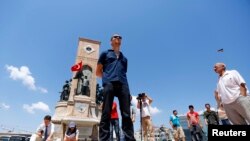 A man stands during a silent protest in Taksim Square in Istanbul June 18, 2013. 