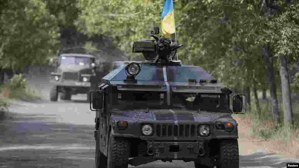 Ukrainian servicemen ride in an armored vehicle in Kramatorsk, Sept. 1, 2014. 