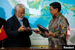 Mantan presiden Timor Leste Xanana Gusmao dan Menteri Koordinator bidang Politik, Hukum, dan Keamanan Wiranto, bertukar dokument setelah pertemuan, Jakarta, 22 Juli 2019. (Foto: Reuters)