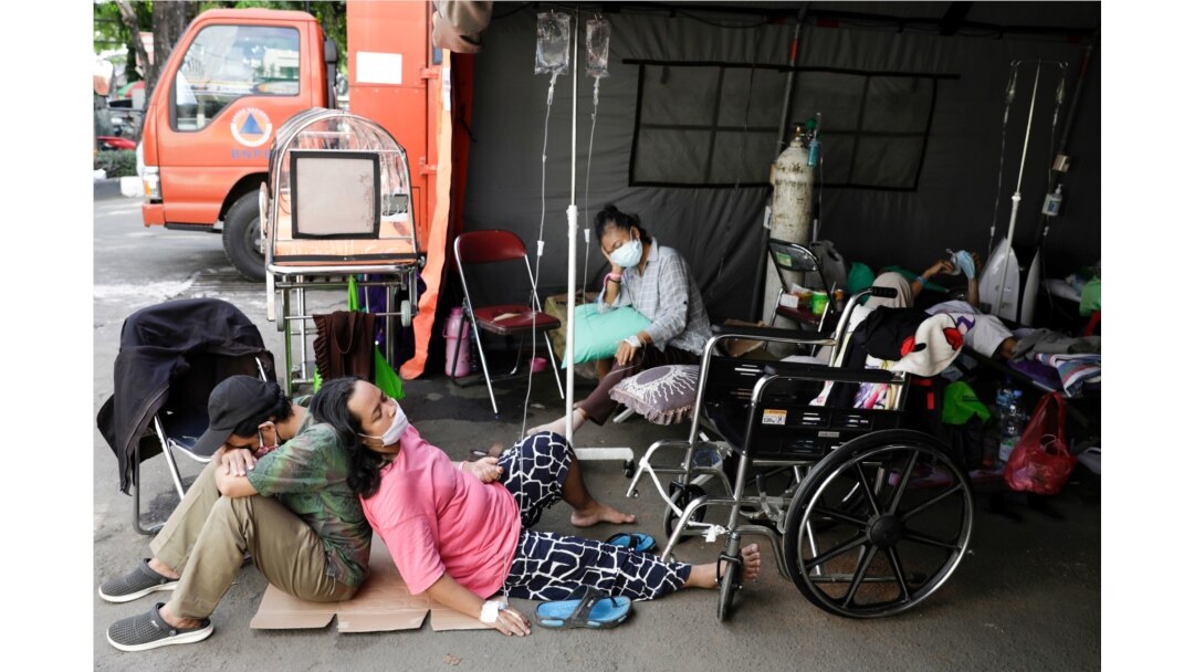 Seorang pasien COVID-19 beristirahat di luar tenda darurat yang didirikan di luar rumah sakit di tengah lonjakan kasus COVID-19 di Bekasi, 25 Juni 2021. (Foto: Willy Kurniawan/Reuters)