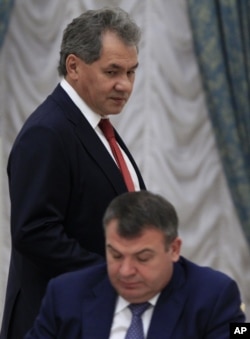 Governor of Moscow Region Sergei Shoigu passes by then Defense Minister Anatoly Serdyukov before a session of the State Council's Presidium at the Kremlin in Moscow, October 9, 2012.