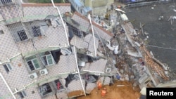 An aerial view shows rescuers looking for survivors at a damaged building after a landslide hit an industrial park in Shenzhen, Guangdong province, China, Dec. 21, 2015.
