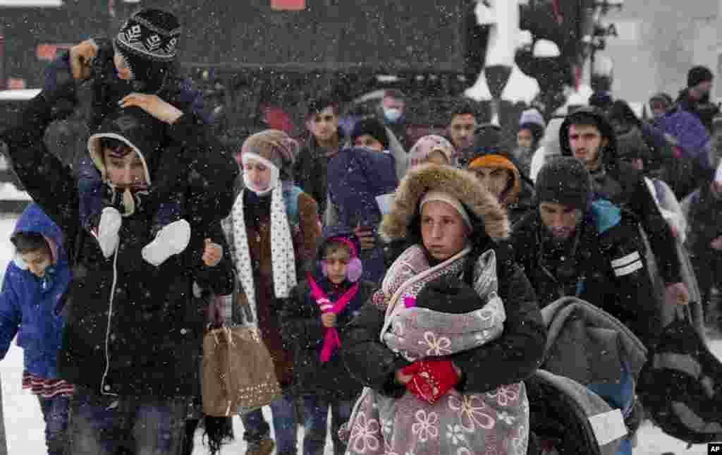 A group of migrants walk towards train station to be transferred to Austria, near the border with Croatia, in Dobova, Slovenia.