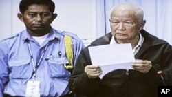 Khieu Samphan, right, former head of state, is seen in the video screen set up in the press center of the U.N.-backed war crimes tribunal on the outskirts of Phnom Penh, Cambodia, Thursday, June 30, 2011. The tribunal on Thursday held its fourth day trial