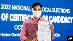 FILE - Ferdinand Marcos Jr. poses after filing his certificate of candidacy for the 2022 presidential elections with the Commission on Elections in Manila, Philippines, Oct. 6, 2021.