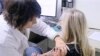 FILE - A woman gets a dose of flu vaccine.