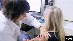 FILE - A woman gets a dose of flu vaccine.
