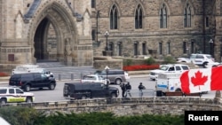 Armed RCMP officers approach Centre Block on Parliament Hilll following a shooting incident in Ottawa October 22, 2014.
