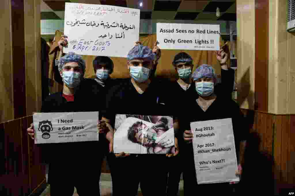 Medical staff at Damascus Countryside Specialized Hospital hold placards condemning a suspected chemical weapons attack on the Syrian town of Khan Sheikhun.