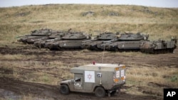 گولان ہائیٹس کے علاقے میں اسرائیلی فوج کی ایک ایمبولینس سرحد پر تعینات ٹینکوں کے نزدیک سے گزر رہی ہے۔