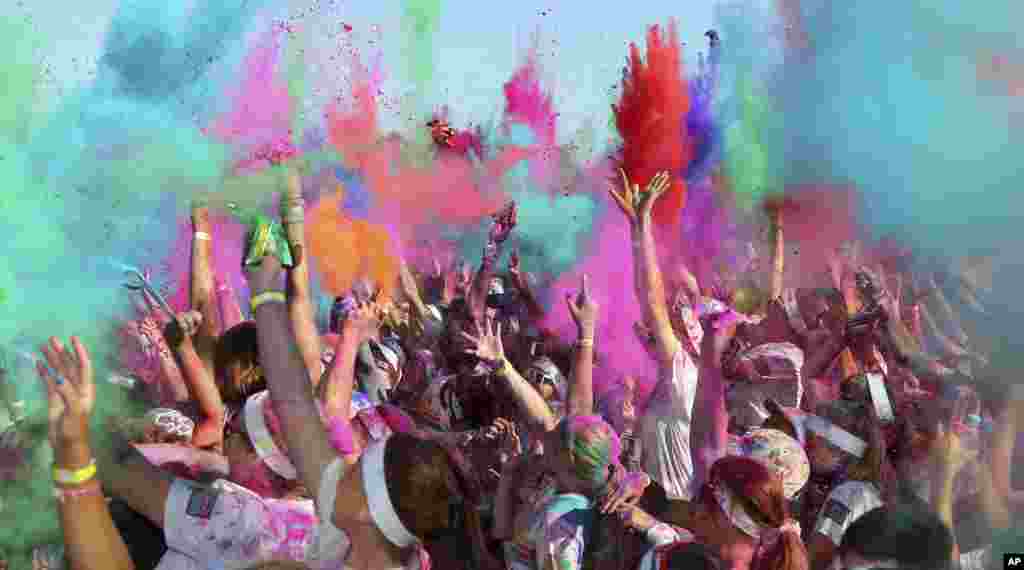 People throw colored powder in the air at the Color Run in Sydney, Australia. The&nbsp; event is a 5-km (3.1-mile) fun run where participants are covered with bright-colored powder at each check station and is less about speed and more about enjoying a day with friends and family.