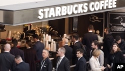 Customers line up at a Starbucks, April 2, 2015 in New York. 