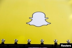FILE - A billboard displays the logo of Snapchat above Times Square in New York.