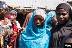 Fourteen-year-old Basira Bello (with blue hijab) is escorted by a female relative to the home of her soon-to-be husband. (C. Oduah/VOA)
