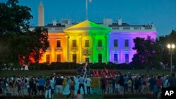 FILE - people gather in Lafayette Park to see the White House illuminated with rainbow colors in commemoration of the Supreme Court's ruling to legalize same-sex marriage in Washington.