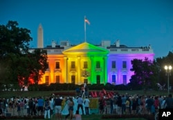 FILE - people gather in Lafayette Park to see the White House illuminated with rainbow colors in commemoration of the Supreme Court's ruling to legalize same-sex marriage in Washington.