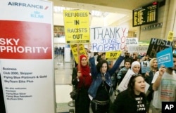 FILE - Demonstrators opposed to President Trump's travel ban march through Tom Bradley International Terminal at Los Angeles International Airport, Feb. 4, 2017. One sign thanks federal judge James L. Robart, who issued a stay of the order.