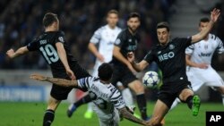 Dani Alves de la Juventus, premier plan, marque le deuxième but de son équipe lors du match de la 16e journée de la Ligue des champions entre le FC Porto et la Juventus au stade Dragao de Porto, au Portugal, 22 février 2017. 