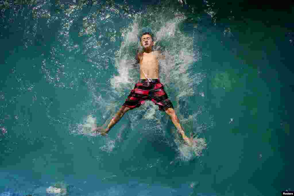 A child plays in a pool during a warm sunny day in Santiago, Chile, March 22, 2015.