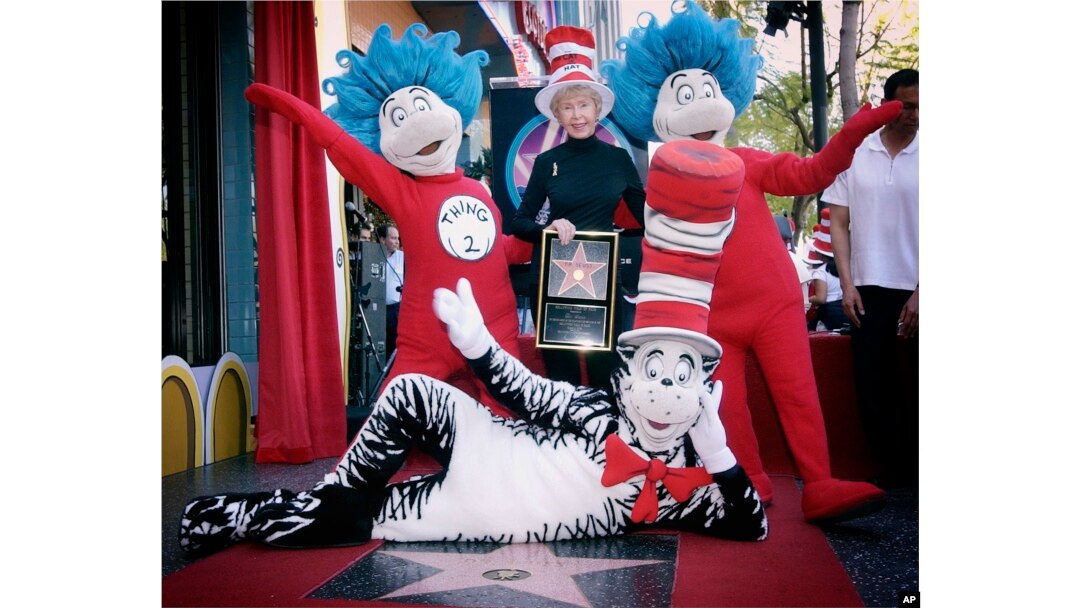 FILE - Audrey Geisel, widow of author Theodor Seuss Geisel, poses with The Cat in the Hat, foreground, and Thing 1 and Thing 2, who are characters from his books, at the dedication of Dr. Seuss' posthumous star on the Hollywood Walk of Fame in Los Angeles, March 11, 2004.