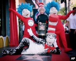 FILE - Audrey Geisel, widow of author Theodor Seuss Geisel, poses with The Cat in the Hat, foreground, and Thing 1 and Thing 2, who are characters from his books, at the dedication of Dr. Seuss' posthumous star on the Hollywood Walk of Fame in Los Angeles, March 11, 2004.