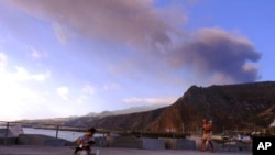 Smoke rises from a volcano on the Spanish isle of La Palma in the Canary Islands, Oct. 7, 2021. The airport on the island shut down again Thursday because of ash from the volcano, which has been erupting for almost three weeks. 