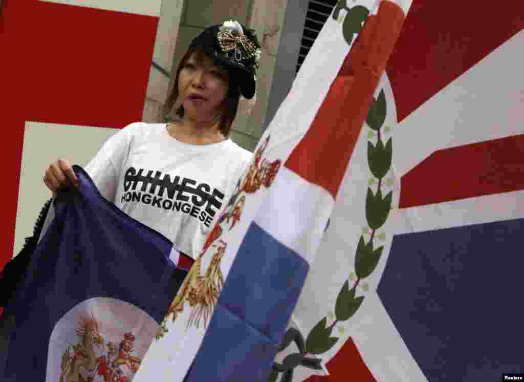 Seorang demonstran, membawa bekas bendera kolonial Hong Kong, berdemonstrasi melawan kontrol China di Konsulat Inggris di Hong Kong (15/6). (Reuters/Bobby Yip)