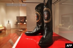 A pair of Ronald Reagan's cowboy boots sit in a case at Christie's where items from the former president and Nancy Reagan's California home are to be auctioned, Sept. 16, 2016, in New York City.