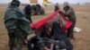 Members of the Syrian Democratic Forces help a woman near the village of Baghuz, in Deir el-Zour province, Syria, March 7, 2019.