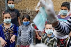 Ilustrasi. Anak-anak Mesir tengah belajar memakai masker sebagai tindakan pencegahan di tengah kekhawatiran tentang penyebaran COVID-19 di distrik Darb Al-Ban di Islamic Cairo, Mesir 13 April 2020. (Foto: Reuters/Mohamed Abd El Ghany)