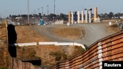 FILE: Prototypes for U.S. President Donald Trump's border wall with Mexico are shown near completion behind the current border fence, in this picture taken from the Mexican side of the border, in Tijuana, Oct. 23, 2017.