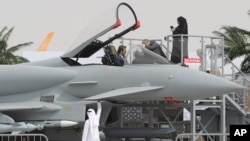 An Emirati woman, top right, and others view a replica of the Eurofighter Typhoon jet during the opening day of the Dubai Airshow in Dubai, UAE, Nov. 17, 2013. 