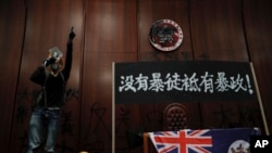 1일 홍콩 입법회를 점거한 시위대가 특별행정구 상징 문장을 훼손하는 모습을 취재진이 촬영하고 있다. 시위대는 벽에 걸린 의원들의 사진 등을 내리고, 스프레이 페인트로 본회의장에 민주화 구호를 적었다.