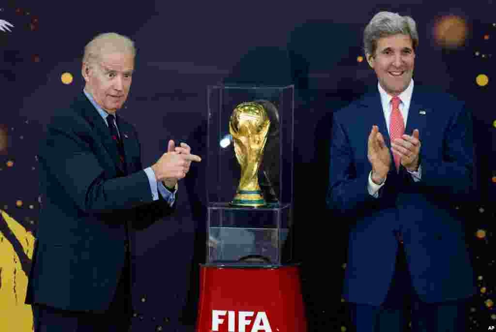 Joe Biden e John Kerry posam para a foto com o troféu do Mundial de Futebol. Abril 14, 2014