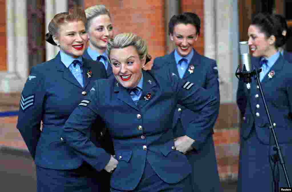 The singing group D-Day Darlings take part in the unveiling ceremony of a permanent war memorial, created by artist and writer Fabian Peake, at St. Pancras International railway station in London.