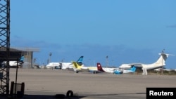 FILE - Airplanes are seen at Mitiga airport, in Tripoli, Libya, April 8, 2019. A large group of African migrants were flown out this week from Libya to their home countries. 