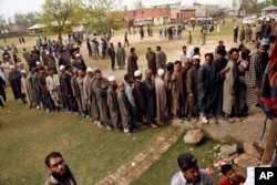 Kashmiri voters stand in a queue to cast their votes outside a polling station at Shadipora, outskirts of Srinagar, Indian controlled Kashmir, April 11, 2019.