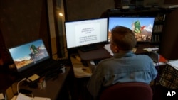 Caroline Clarin works in her basement on applications to get the Afghans who worked for her program out of the country, in Dalton, Minn., Oct. 26, 2021.