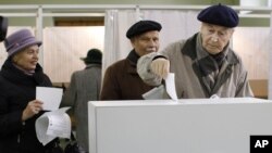  A Lithuanian voter casts his ballot at a polling station in Vilnius, Lithuania, October 14, 2012.