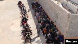 Les migrants clandestins sont assis dans un centre de détention provisoire après avoir été détenus par les autorités libyennes à Tripoli , en Libye Octobre 12 2015.