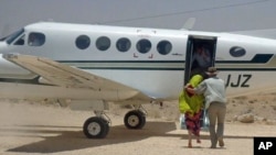 British hostage Judith Tebbutt (L) is escorted to a plane at Adado airport after she was released in central Somalia, March 21, 2012.
